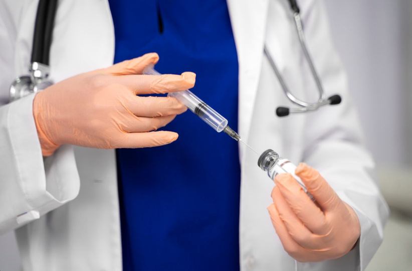 A clinician drawing a prescribed peptide from a vial into a small syringe