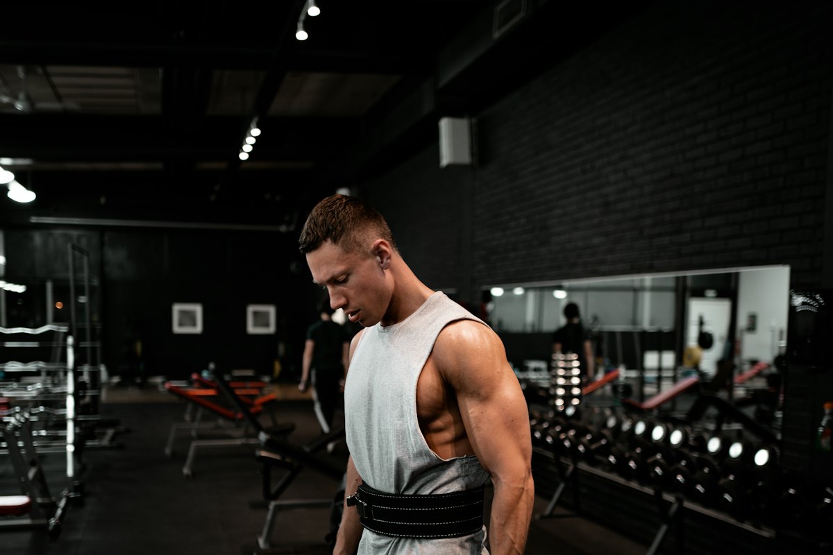 A man holding a weight plate during a gym session