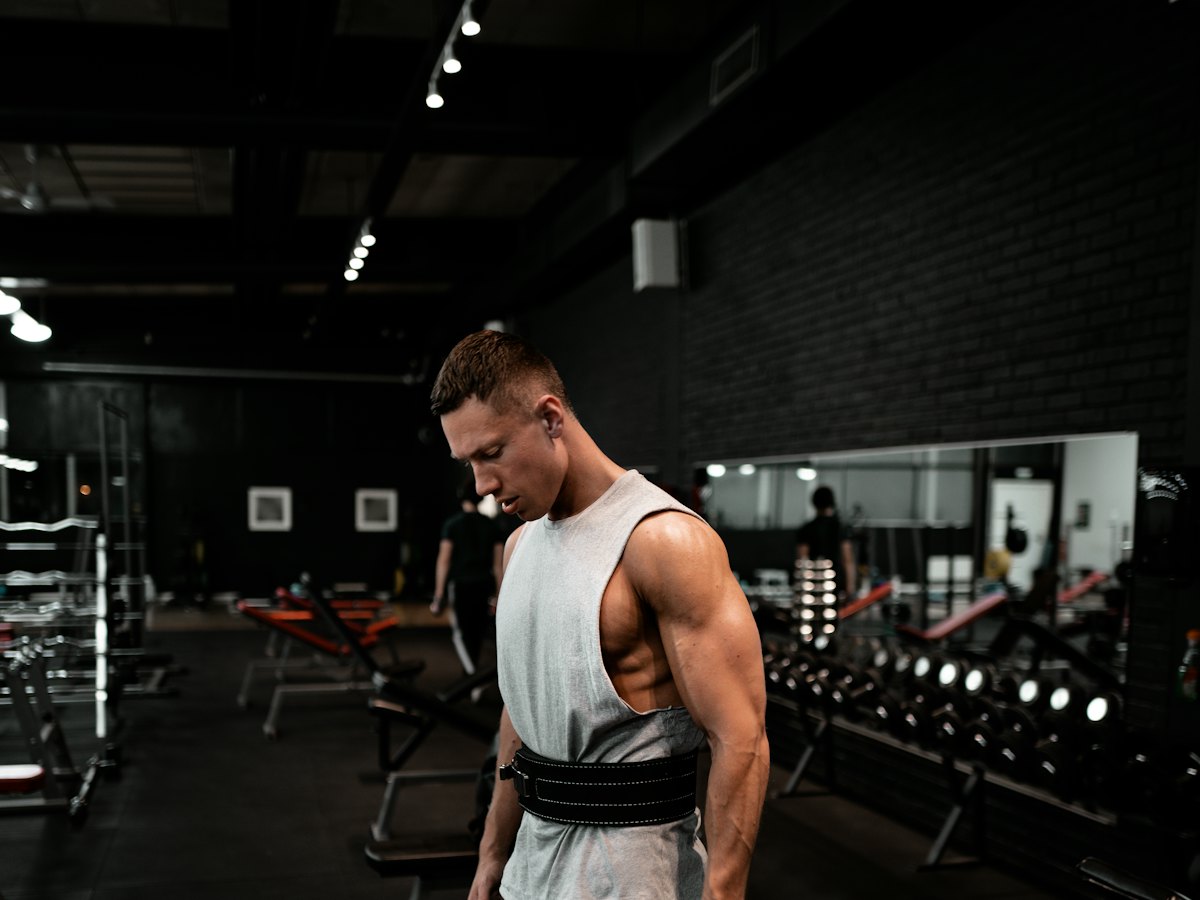 A man holding a weight plate in a gym