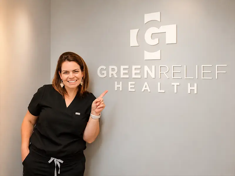 Dr. Lauren Nawrocki at the Green Relief Health signage wall